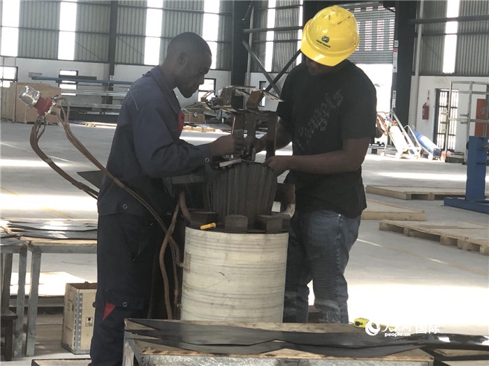 經(jīng)貿(mào)合作區(qū)廠房?jī)?nèi)，當(dāng)?shù)毓と苏诰o張作業(yè)。人民網(wǎng)記者 黃培昭攝