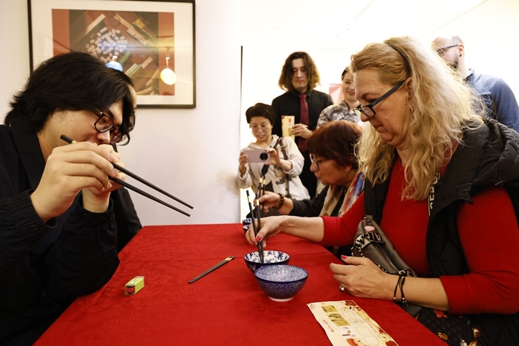 羅馬尼亞觀眾體驗(yàn)用筷子夾花生。中國文化中心供圖