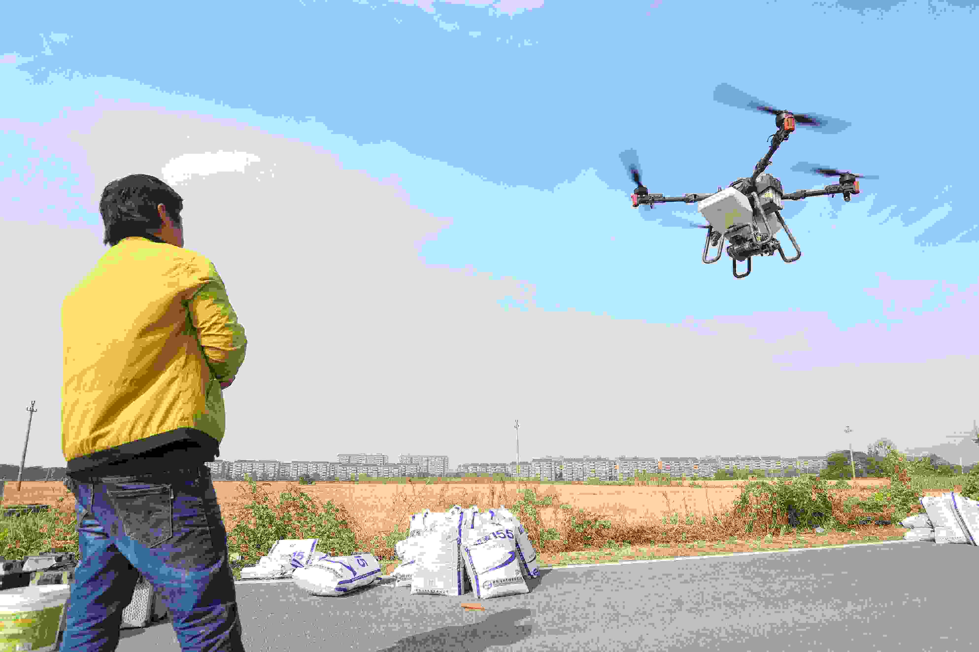 2023年11月15日，浙江嘉興，南湖區(qū)七星街道一處農(nóng)田里，農(nóng)民操縱無人機進行冬小麥飛播。