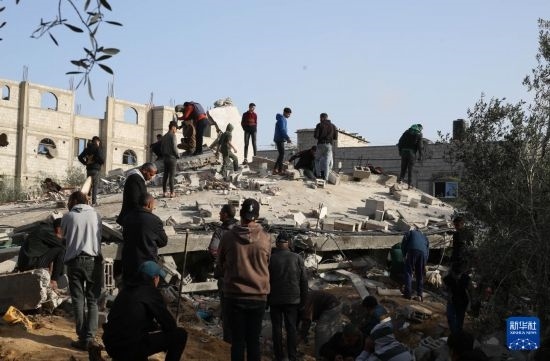  3月3日，在加沙地帶南部城市拉法，人們查看被以軍空襲破壞的建筑。新華社發(fā)（哈立德·奧馬爾攝）