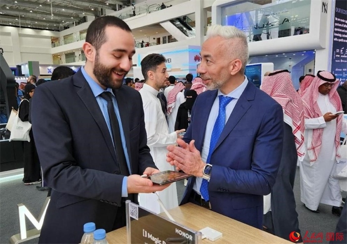 兩名觀眾在榮耀手機(jī)展臺(tái)前交流。人民網(wǎng)記者 管克江攝