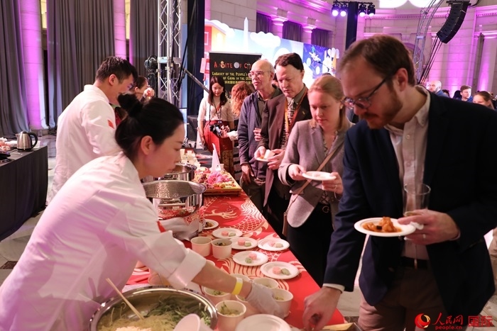 當(dāng)?shù)貢r(shí)間3月7日晚，華盛頓聯(lián)合車站廣場舉行駐美使團(tuán)“使館主廚挑戰(zhàn)賽”。圖為當(dāng)?shù)孛癖娫谥袊古_前體驗(yàn)中國美食。人民網(wǎng)記者 李志偉攝