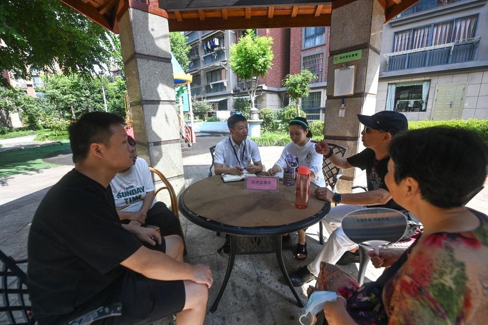 △2023年7月21日，在位于浙江杭州臨安區(qū)錦南街道水岸陽光小區(qū)的陽光議事廳，街道干部在聽取居民們反映的問題及意見。