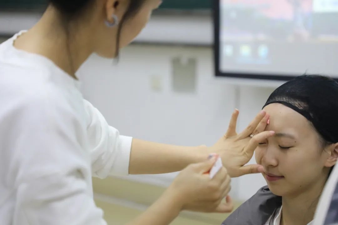 課堂上，一名學(xué)生在體驗(yàn)上戲妝。學(xué)校供圖