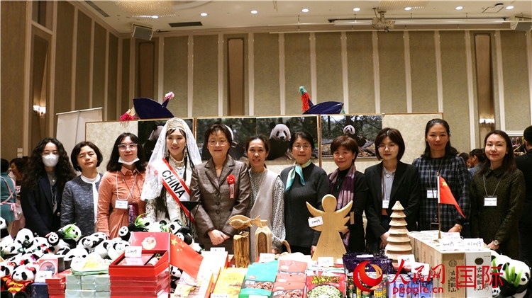 中國(guó)駐日本大使吳江浩夫人丁玥（左五）與使館人員在展位前合影留念。人民網(wǎng) 許可攝