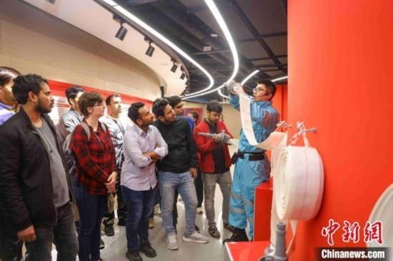 5月9日，工作人員指導留學生正確使用消防水帶。張鷹 攝