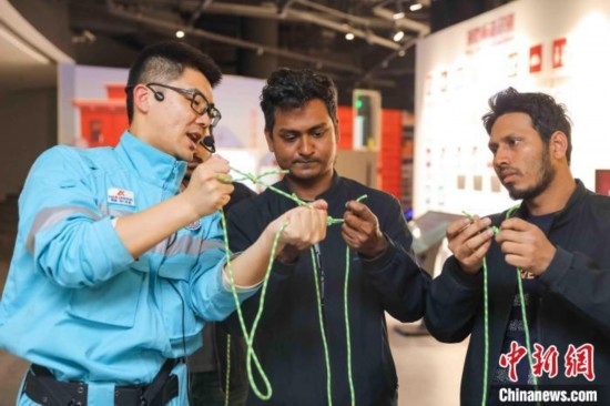 5月9日，工作人員指導留學生學習打繩結(jié)。張鷹 攝