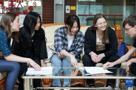 4月28日，宋智孝（右二）和胡靈月（左一）在北京首都師范大學(xué)校園內(nèi)與同學(xué)交流。新華社記者 彭子洋 攝