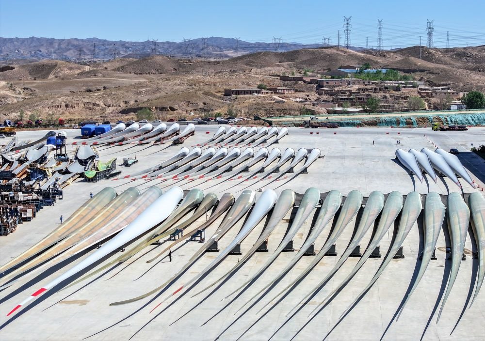 2024年5月11日拍攝的碼放在內蒙古包頭市石拐區(qū)一家風電設備制造企業(yè)廠區(qū)內的葉片（無人機照片）。新華社記者 連振 攝