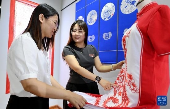 5月31日，在衡水市阜城縣一家剪紙工作室，游客在觀賞帶有剪紙?jiān)氐钠炫邸? width=