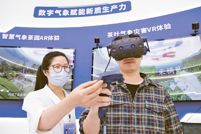 2024年5月23日，第七屆數(shù)字中國建設(shè)峰會(huì)現(xiàn)場(chǎng)體驗(yàn)區(qū)在福州海峽國際會(huì)展中心向?qū)I(yè)觀眾開放。本次現(xiàn)場(chǎng)體驗(yàn)區(qū)圍繞本屆峰會(huì)主題“釋放數(shù)據(jù)要素價(jià)值，發(fā)展新質(zhì)生產(chǎn)力”，設(shè)置“數(shù)字惠民”、“數(shù)字能力”、“數(shù)字基礎(chǔ)”、“數(shù)字生態(tài)”、“數(shù)字賦能”五大板塊。圖為一名觀眾（右）在數(shù)字氣象賦能新質(zhì)生產(chǎn)力展臺(tái)上進(jìn)行體驗(yàn)。 新華社記者 魏培全/攝