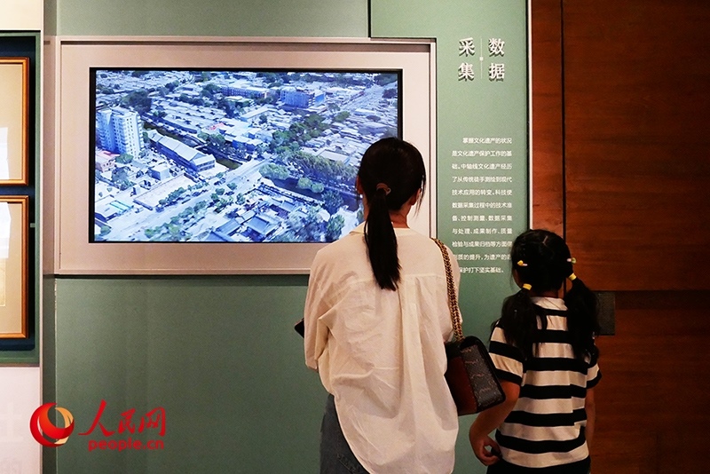 家長正在帶孩子參觀“輝煌中軸”專題展。人民網(wǎng)記者 韋衍行攝