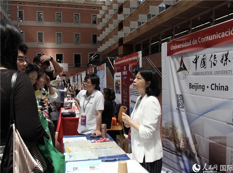 旅西華人華僑在展臺前咨詢。人民網(wǎng)記者 許海林?jǐn)z