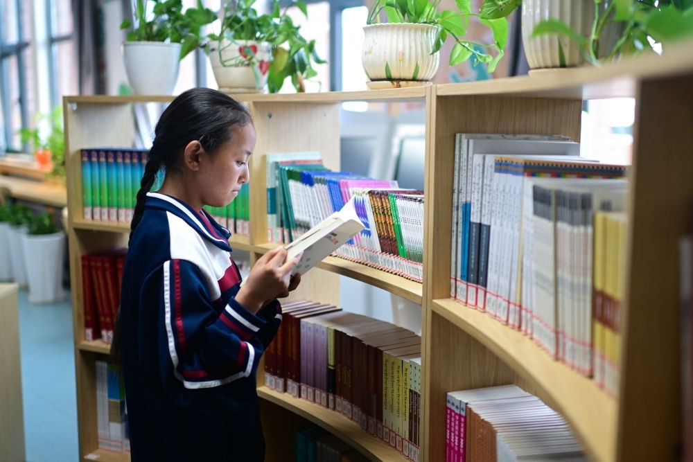 6月18日，果洛西寧民族中學(xué)學(xué)生尼東拉毛在圖書室看書。