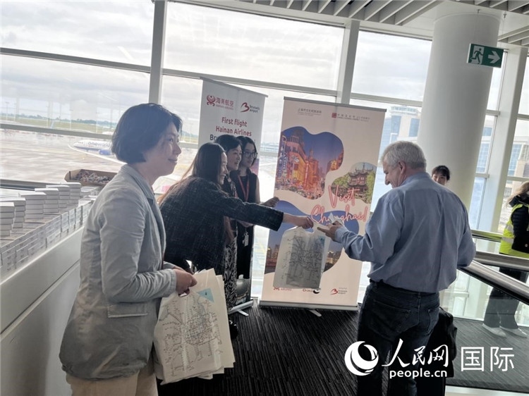 圖為工作人員向乘客發(fā)放復(fù)航首班禮物。 牛瑞飛攝