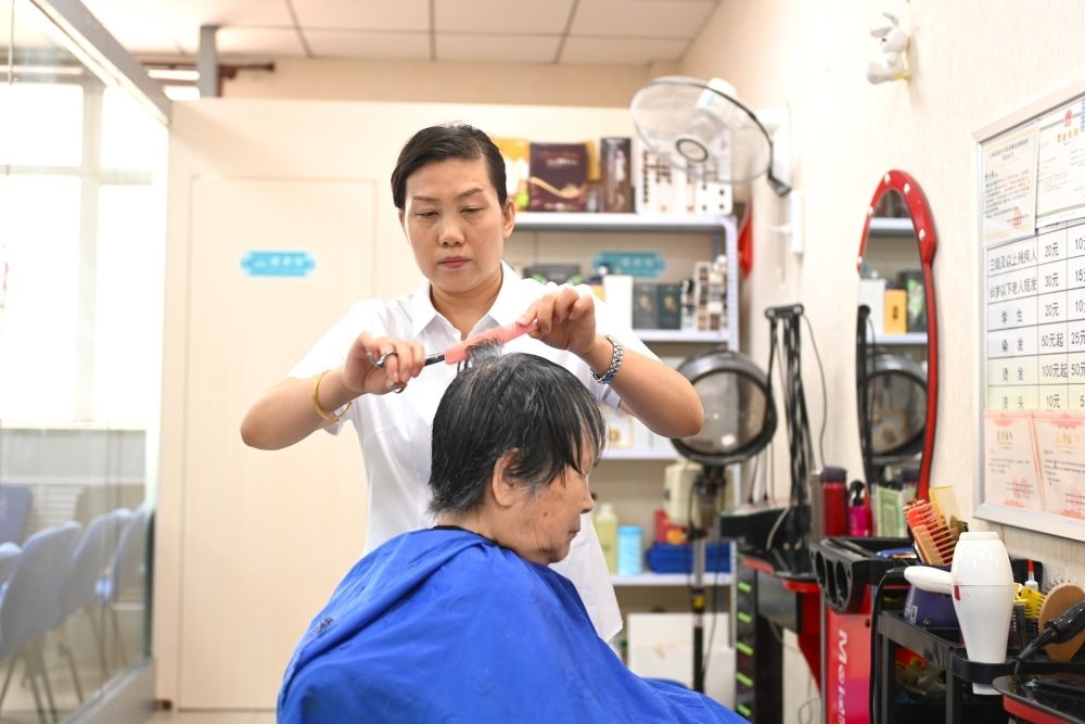 6月20日，長(zhǎng)城花園社區(qū)的志愿者為居民理發(fā)。