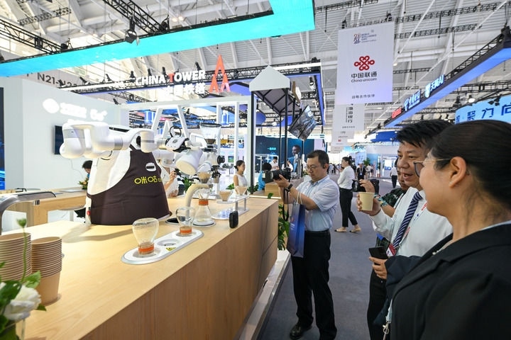 6月20日，與會(huì)者品嘗機(jī)器人沖調(diào)出的咖啡。新華社記者 孫凡越 攝