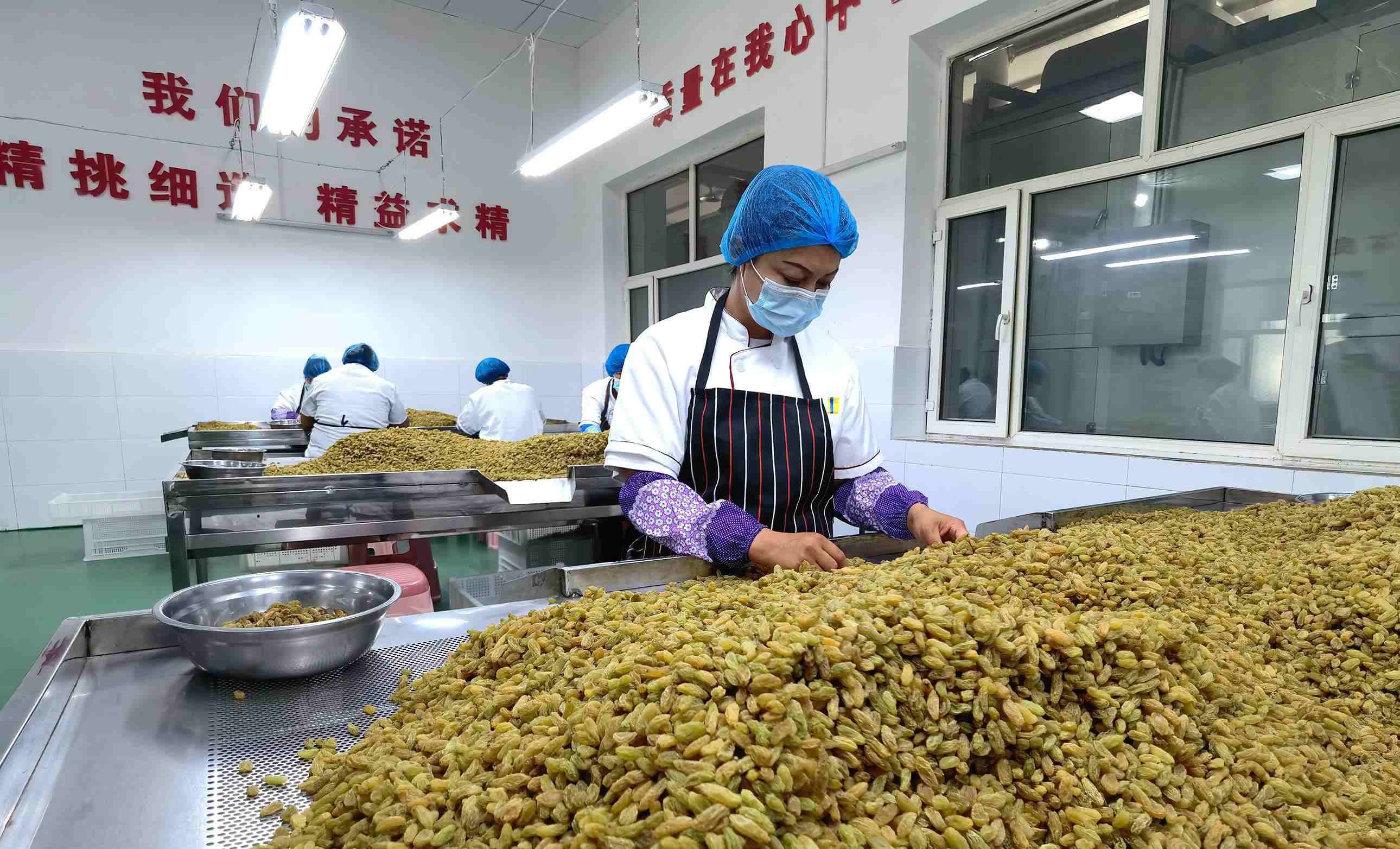 新疆吐魯番市高昌區(qū)亞爾鎮(zhèn)新城西門(mén)村，村民們?cè)诜謷咸迅伞? width=