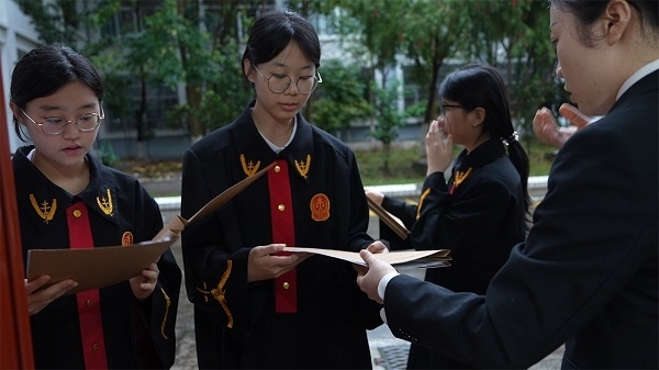 圖①：武平法院干警向學生分發(fā)道具卷宗。