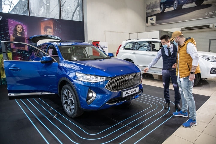 2021年4月1日，銷售人員在哈薩克斯坦阿拉木圖市經(jīng)銷商店向消費(fèi)者介紹哈弗汽車。新華社發(fā)（阿斯塔納汽車公司供圖）