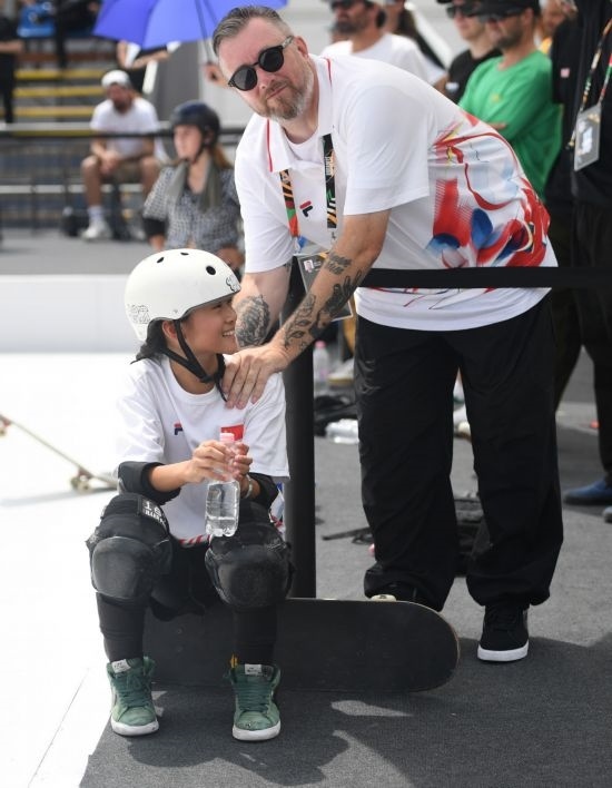 6月20日，鄭好好（左）在比賽間隙與教練互動，她在預賽中最佳成績?yōu)?2.60分。當日，巴黎奧運會資格系列賽布達佩斯站滑板女子碗池預賽在布達佩斯舉行。新華社記者 賀燦鈴 攝