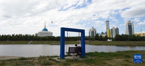 6月30日，一名女子在哈薩克斯坦首都阿斯塔納伊希姆河畔休息。新華社記者 王建華 攝