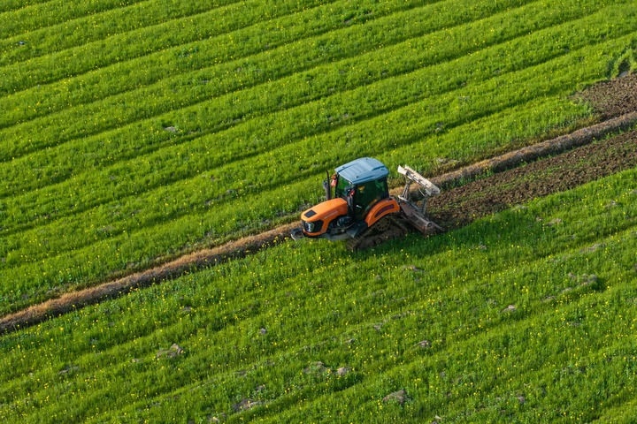 2024年3月19日，在湖南省常德市鼎城區(qū)謝家鋪鎮(zhèn)港中坪村，村民駕駛農(nóng)機(jī)翻耕田地（無(wú)人機(jī)照片）。新華社記者 陳思汗 攝
