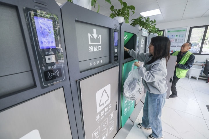 2024年4月10日，在浙江省湖州市吳興區(qū)飛英街道新華府小區(qū)內(nèi)，居民在垃圾分類智能系統(tǒng)的指導(dǎo)下進(jìn)行垃圾分類投放，居民的投放情況將實(shí)時(shí)匯總到智慧服務(wù)平臺(tái)，會(huì)有相應(yīng)的積分獎(jiǎng)勵(lì)。新華社記者 徐昱 攝