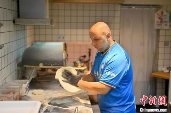 近日，韋榮耀在自家披薩小店內(nèi)忙活。俞靖 攝