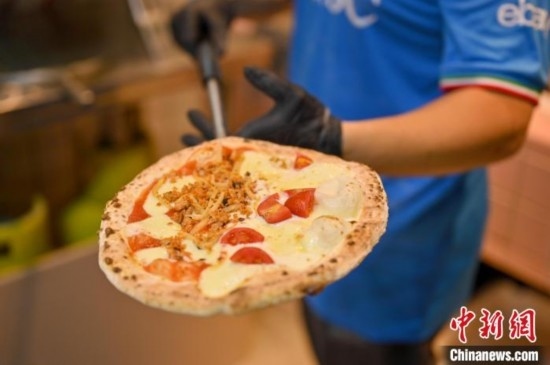 近日，韋榮耀展示他制作的“老友味”披薩。 俞靖 攝