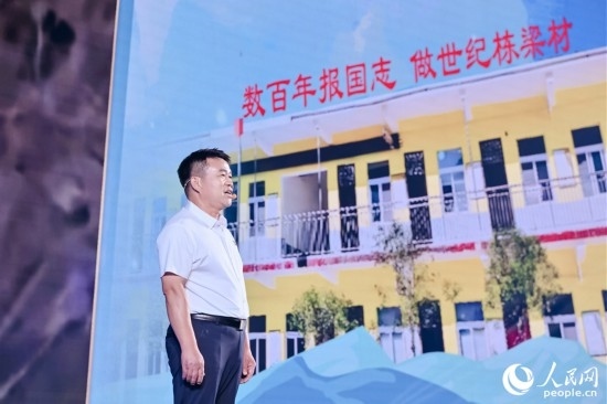 張玉滾分享用一根扁擔(dān)送孩子們走出大山的故事。人民網(wǎng)攝