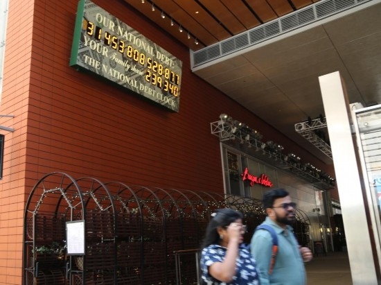 2023年5月29日，人們經(jīng)過美國紐約曼哈頓的“國債鐘”。“國債鐘”是一個大型計數(shù)器，它實時更新美國的公共債務總額，并顯示出每個美國家庭所要負擔的數(shù)額。 新華社記者劉亞南攝