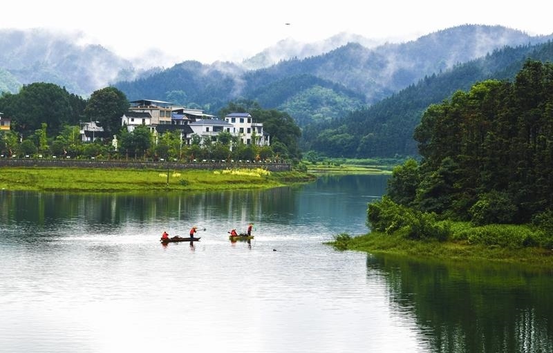 2024年6月5日，志愿者在湖南常寧市洋泉水庫清理水面漂浮物。