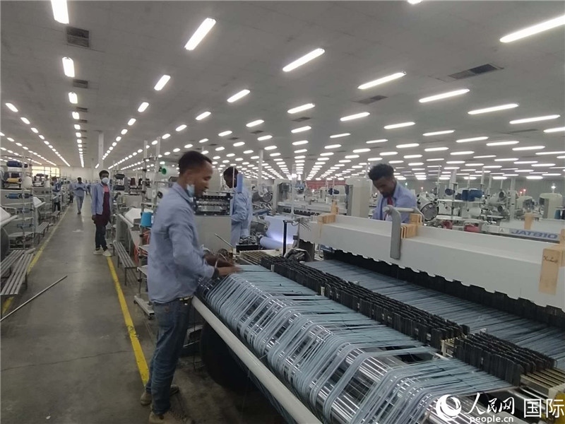無錫金茂埃塞面料廠車間內(nèi)，當(dāng)?shù)毓と苏谝唤z不茍地作業(yè)。人民網(wǎng)記者 黃培昭攝