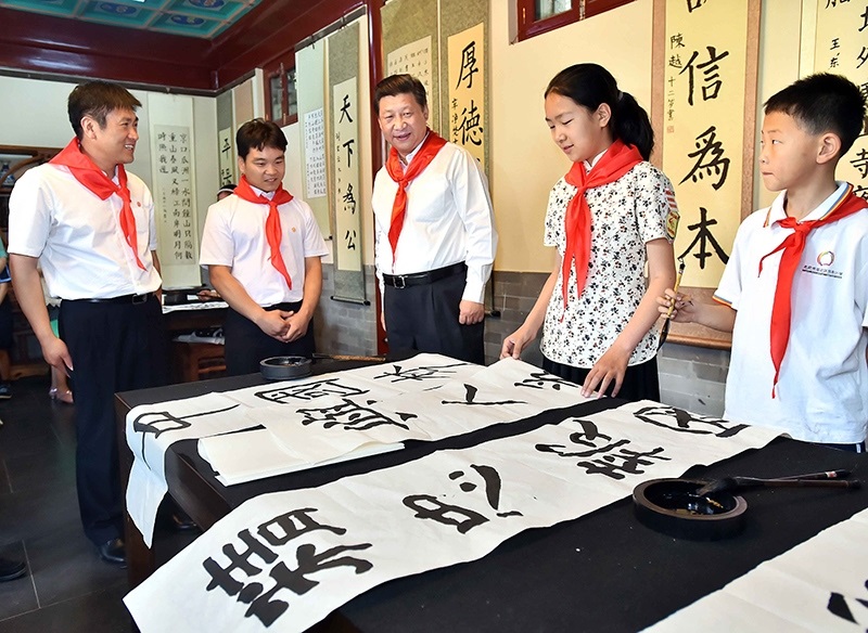 2014年5月30日，習(xí)近平總書記來到北京市海淀區(qū)民族小學(xué)，參加慶?！傲弧眹H兒童節(jié)活動。這是總書記觀看學(xué)生書寫的毛筆字。