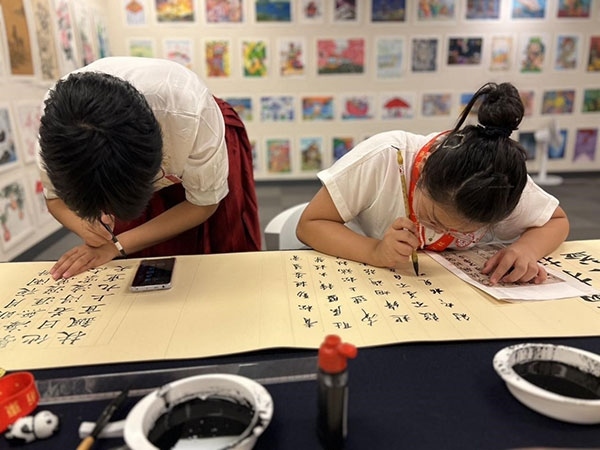 參加本次展覽的青少年在現(xiàn)場進(jìn)行書法創(chuàng)作。主辦方供圖