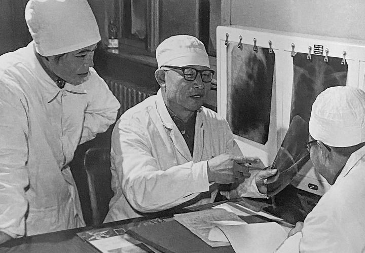 1980年1月16日，中日友好醫(yī)院首任院長辛育齡（中）在內(nèi)蒙古結(jié)核病院與胸外科醫(yī)師討論病例（翻拍照片）。 新華社發(fā)