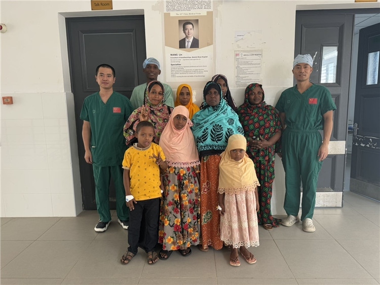 李廣（右一）和王林醫(yī)生與部分患者合影。中國(guó)援桑醫(yī)療隊(duì)供圖