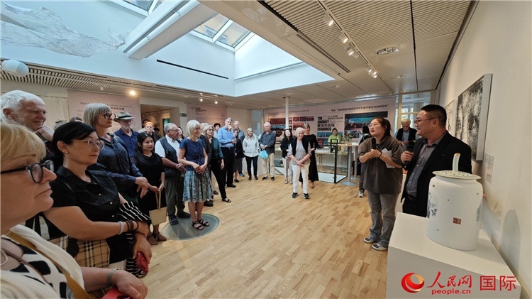 參展人、景德鎮(zhèn)陶瓷大學美術學院副院長邵長宗（右一）向來賓介紹參展作品。人民網記者 殷淼攝