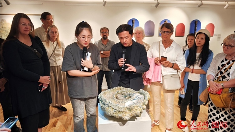 參展人、景德鎮(zhèn)陶瓷大學設計藝術學院副院長余劍峰（中）向來賓介紹參展作品。人民網記者 殷淼攝