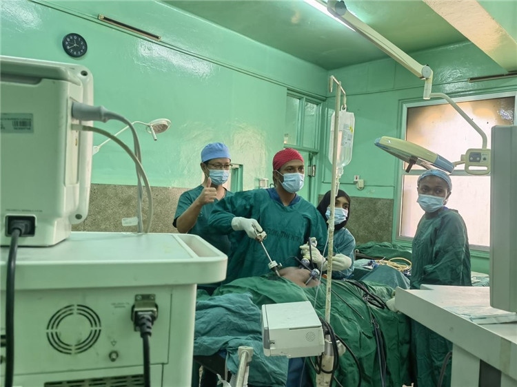隊長蔣國慶（左一）關(guān)注當?shù)蒯t(yī)生手術(shù)情況。中國援桑醫(yī)療隊供圖