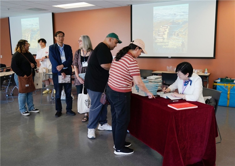 作者顧春芳在活動(dòng)現(xiàn)場簽名贈(zèng)書。羅先勇攝