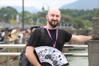 俄羅斯塔斯社執(zhí)行編輯葉夫根尼·扎多羅日內在都江堰魚嘴拍照留念。（李佩藺 攝）