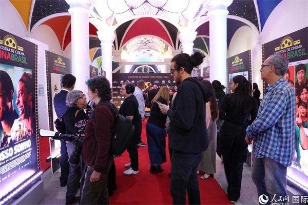 為期4天的第三屆中國－巴西電影展期間，來自中巴兩國的14部參展影片受到巴西電影愛好者和社會各界人士好評，圖為當(dāng)?shù)赜^眾在影展舉辦地巴西里約熱內(nèi)盧勞拉—阿爾維姆文化之家的迎賓廳欣賞參展電影海報。 人民網(wǎng)記者 陳一鳴攝