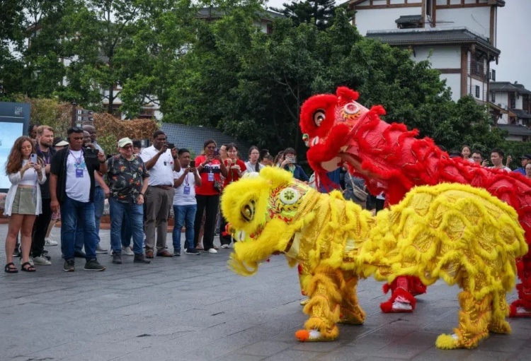 2024“一帶一路”媒體合作論壇聯(lián)合采訪調(diào)研行成員在樂(lè)山蘇稽古鎮(zhèn)觀看非遺舞獅表演。本報(bào)記者 伊霄攝