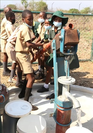 △2021年11月，在津巴布韋南馬塔貝萊蘭省省會關(guān)達(dá)的塞農(nóng)多小學(xué)，學(xué)生從中國援建水井里打水。