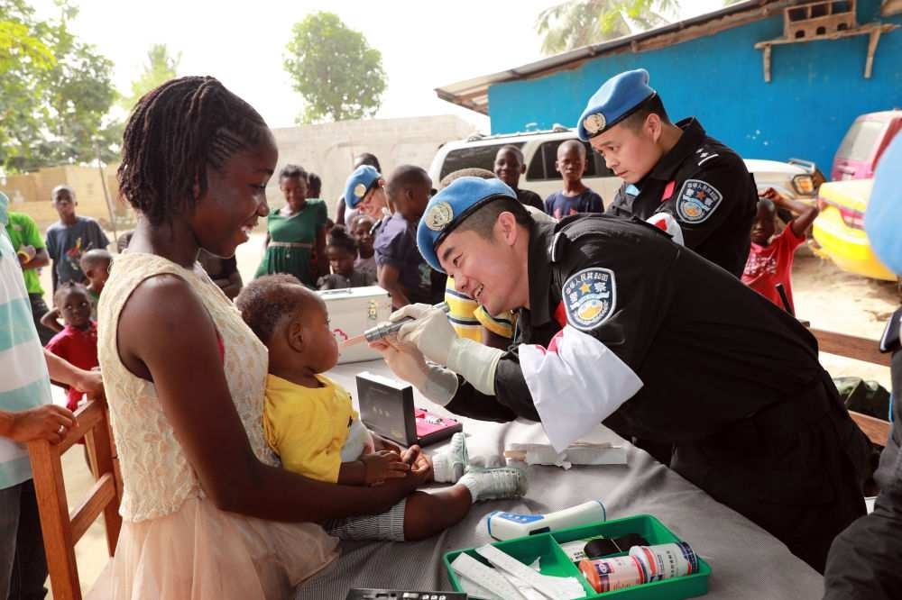 2017年12月28日，在利比里亞蒙羅維亞，中國(guó)維和警察防暴隊(duì)醫(yī)療人員為兒童做口腔檢查。