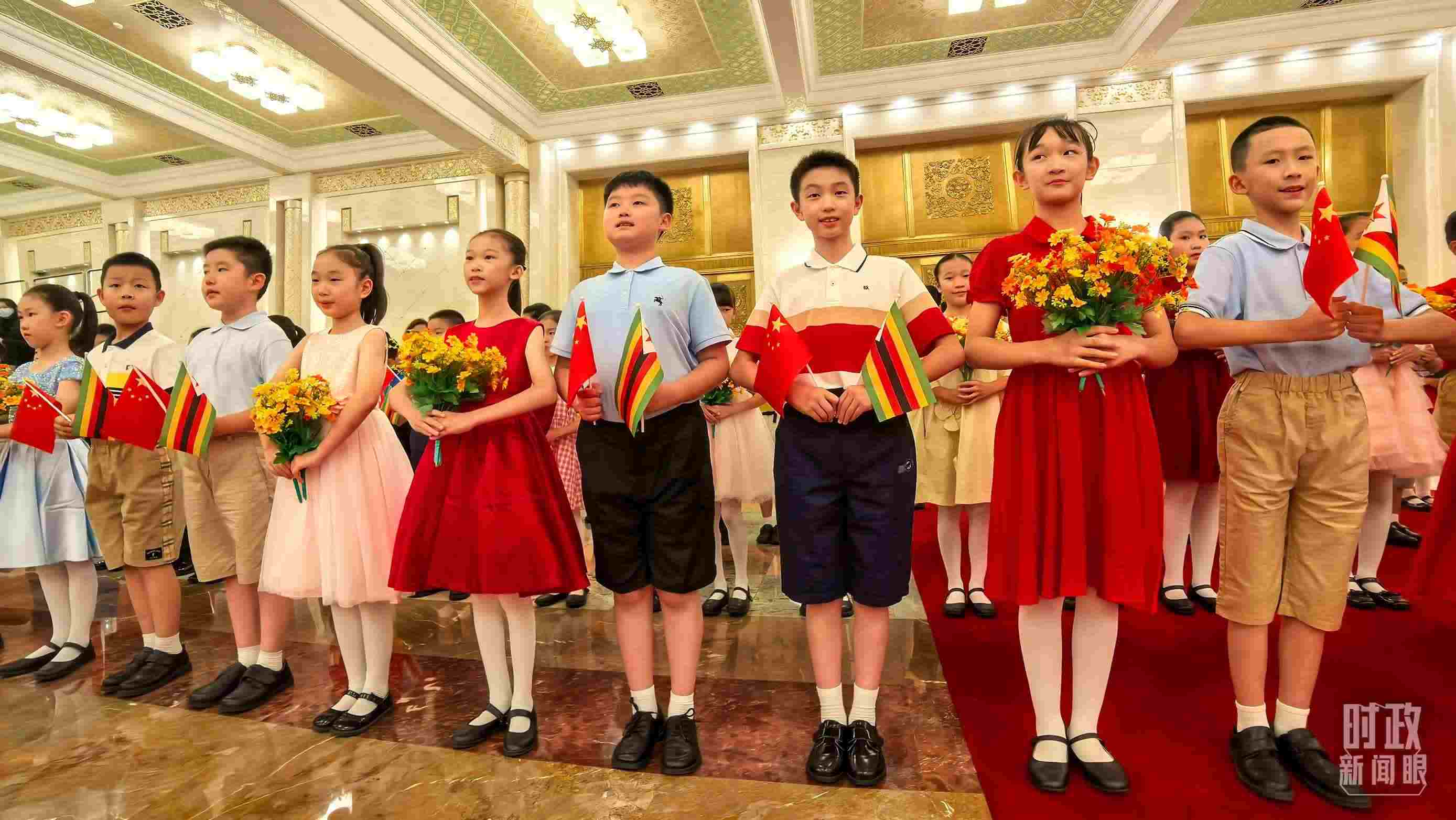 △現(xiàn)場歡迎津巴布韋總統(tǒng)訪華的青少年。（總臺央視記者鐘銳拍攝）