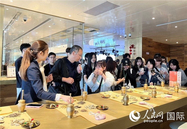 1. 日中友好協(xié)會青年代表團一行學習中醫(yī)香囊制作工序。（人民網記者陳思 攝）