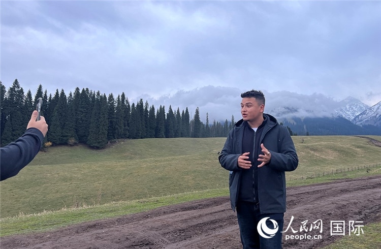 在庫(kù)爾德寧，吾買爾江被雪山美景震撼，即興錄制了短視頻作品。人民網(wǎng)記者曾書柔攝